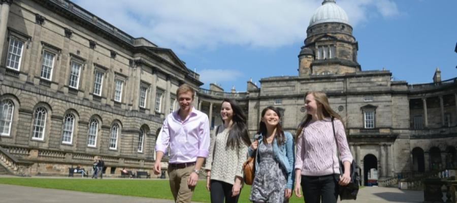 A picture of four students walking in the Old College